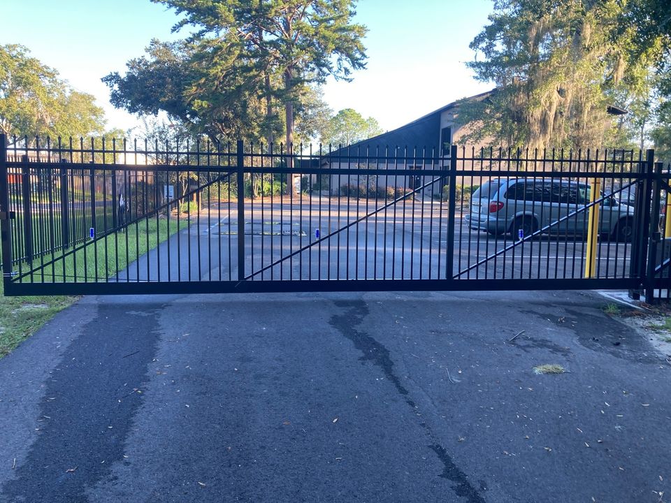 Black ornamental double driveway gate at a commercial property.