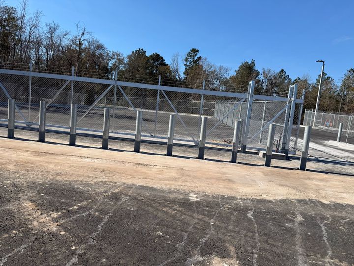 Substantial galvanized chain-link gate system on a heavy-duty post.