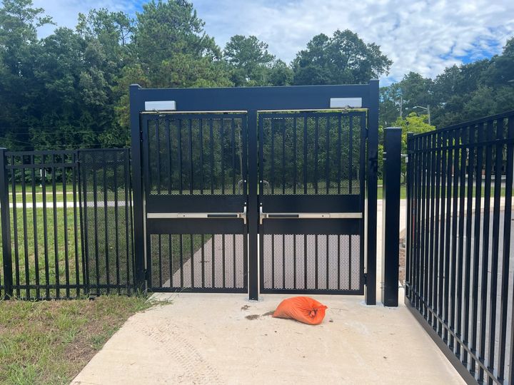 Black ornamental double pedestrian gate with push-bar egress hardware.