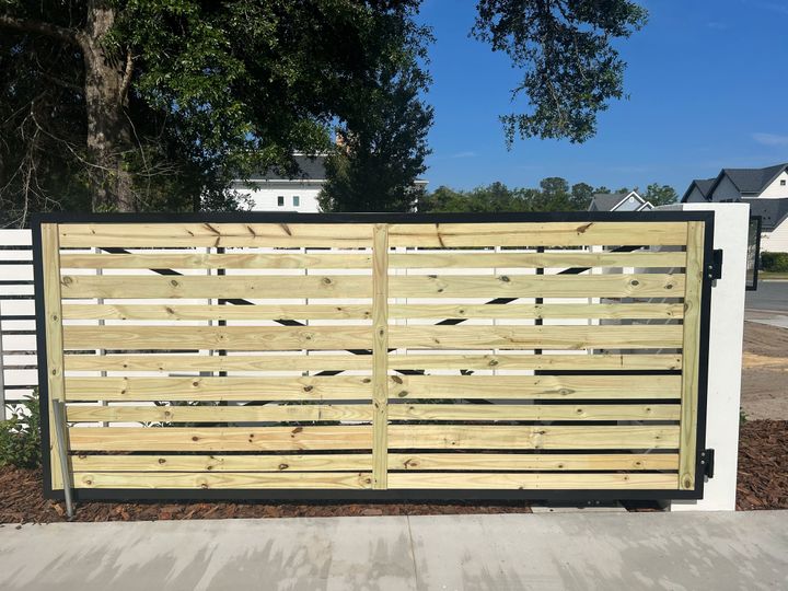 Horizontal wood-infill double swing gate with a black metal frame.